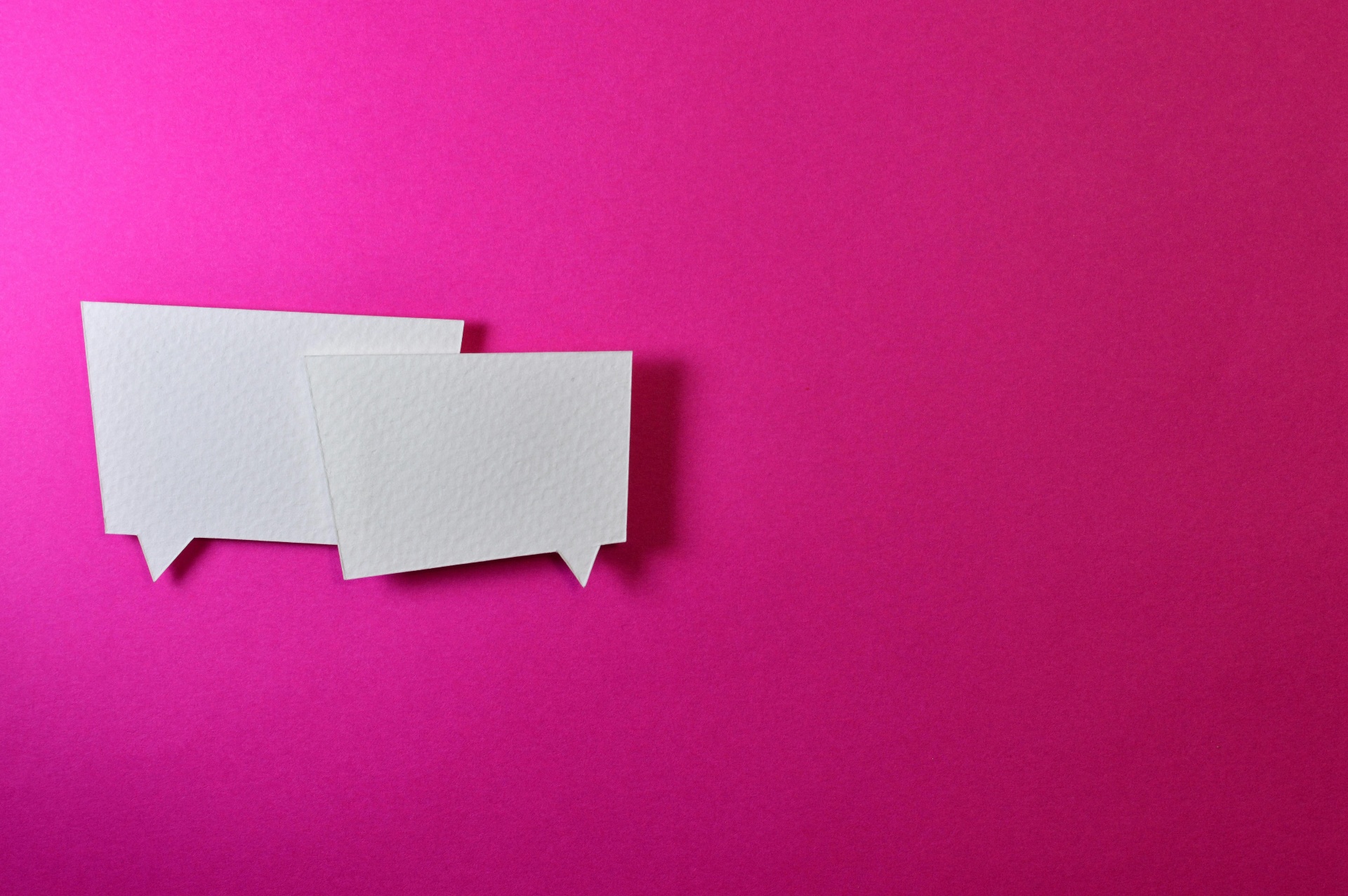 Paper speech bubbles on a magenta background